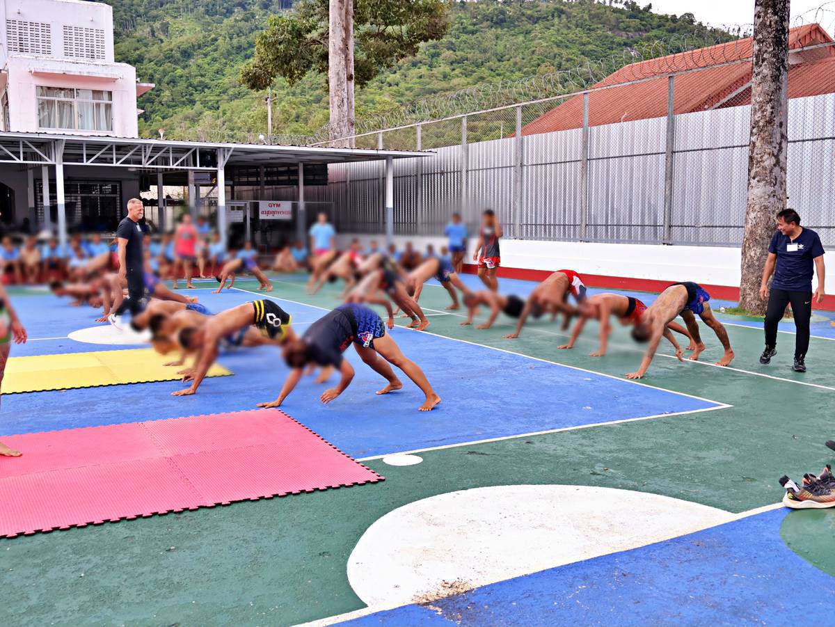 Inmates and coaches taking part in a group functional fitness session at Koh Samui Prison